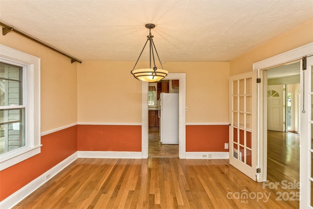 20 Kenilwood Pl, Asheville, NC 28803 - unfurnished dining area featuring wood finished floors, baseboards, and a textured ceiling