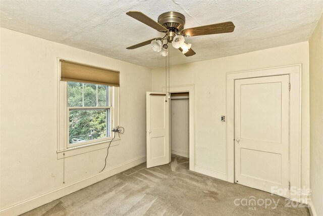 20 Kenilwood Pl, Asheville, NC 28803 - unfurnished bedroom featuring light carpet, a textured ceiling, baseboards, ceiling fan, and a closet