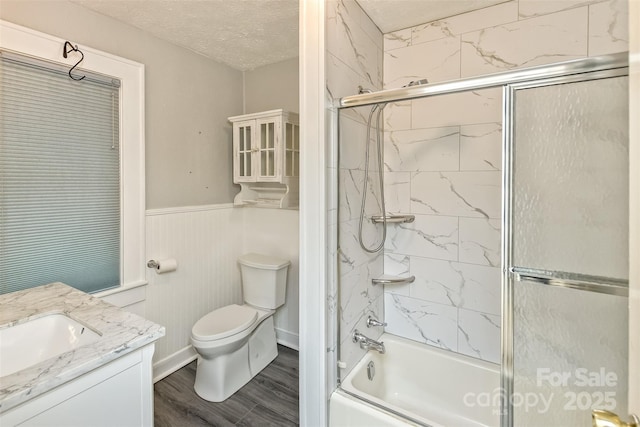 20 Kenilwood Pl, Asheville, NC 28803 - bathroom with vanity, toilet, combined bath / shower with glass door, a wainscoted wall, and wood finished floors