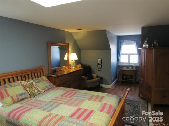 1619 Bellamy Cir, Albemarle, NC 28001 - bedroom with wood finished floors, vaulted ceiling, and baseboards