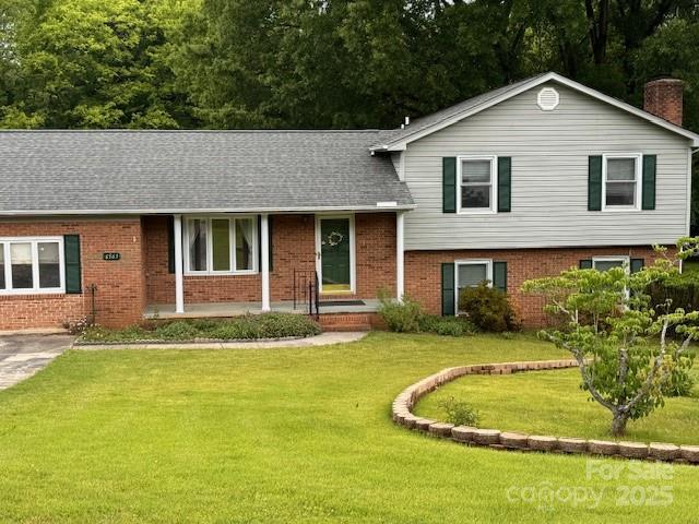 6561 Weldon Cir NW, Concord, NC 28027 - split level home featuring brick siding, a front yard, and a chimney