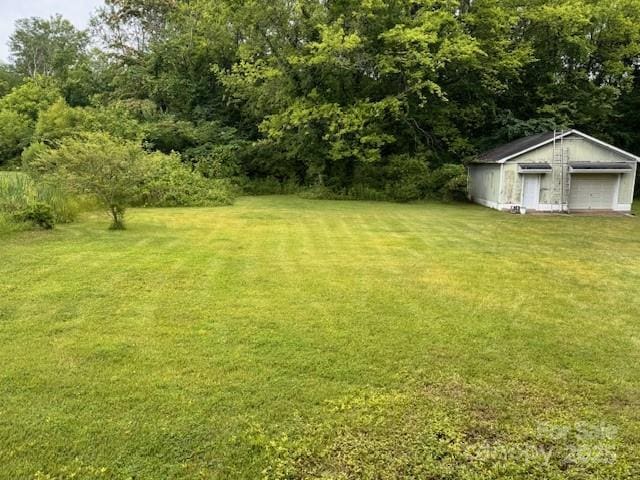 6561 Weldon Cir NW, Concord, NC 28027 - view of green lawn featuring an outbuilding and a garage