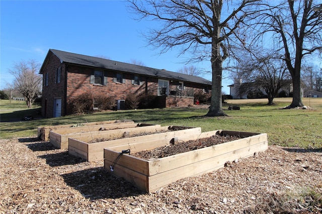 2653 Fairway Acres Cir, Lenoir, NC 28645 - rear view of house featuring a lawn, brick siding, and a vegetable garden