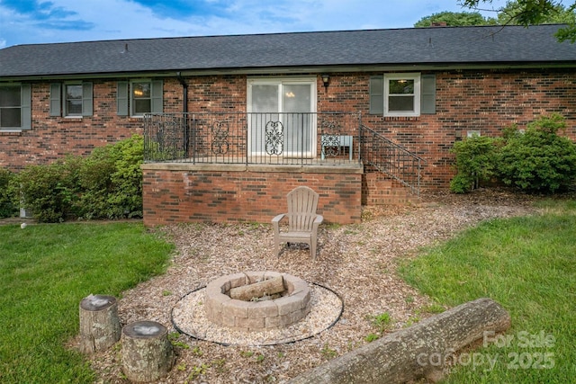 2653 Fairway Acres Cir, Lenoir, NC 28645 - rear view of house with an outdoor fire pit, a shingled roof, brick siding, and a yard