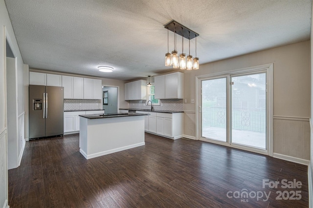2653 Fairway Acres Cir, Lenoir, NC 28645 - kitchen featuring stainless steel fridge with ice dispenser, dark countertops, a textured ceiling, decorative backsplash, and white cabinets