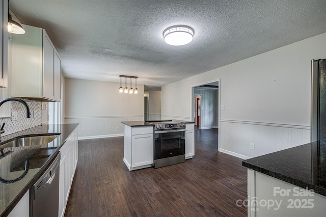 2653 Fairway Acres Cir, Lenoir, NC 28645 - kitchen with stainless steel appliances, dark wood-style floors, a wainscoted wall, white cabinetry, and a textured ceiling