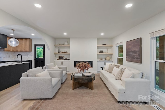3326 Winterfield Pl, Charlotte, NC 28205 - living area featuring arched walkways, recessed lighting, plenty of natural light, a warm lit fireplace, and a baseboard heating unit