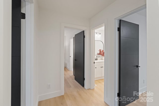 3326 Winterfield Pl, Charlotte, NC 28205 - hallway featuring light wood-type flooring, baseboards, and a sink