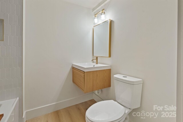 3326 Winterfield Pl, Charlotte, NC 28205 - bathroom with vanity, toilet, wood finished floors, and baseboards