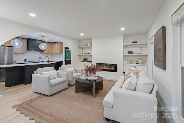 3326 Winterfield Pl, Charlotte, NC 28205 - living room featuring arched walkways, a glass covered fireplace, light wood-style floors, and recessed lighting