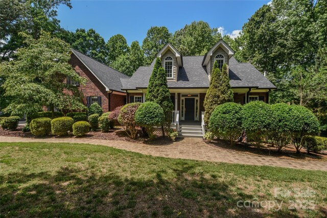 118 Tayport Dr, Troutman, NC 28166 - cape cod-style house with a front lawn, covered porch, and a shingled roof