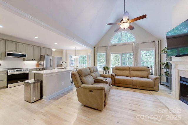 118 Tayport Dr, Troutman, NC 28166 - living room featuring high vaulted ceiling, light wood-style flooring, a premium fireplace, ceiling fan, and recessed lighting