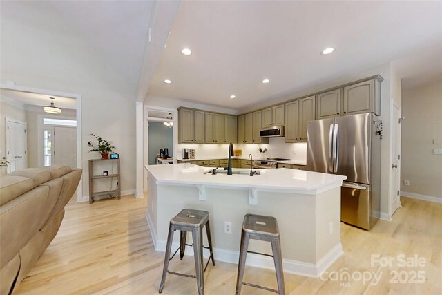 118 Tayport Dr, Troutman, NC 28166 - kitchen featuring stainless steel appliances, a sink, a kitchen bar, light countertops, and recessed lighting