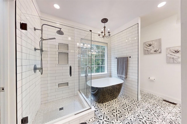 118 Tayport Dr, Troutman, NC 28166 - bathroom with a freestanding tub, a stall shower, a chandelier, tile patterned flooring, and baseboards