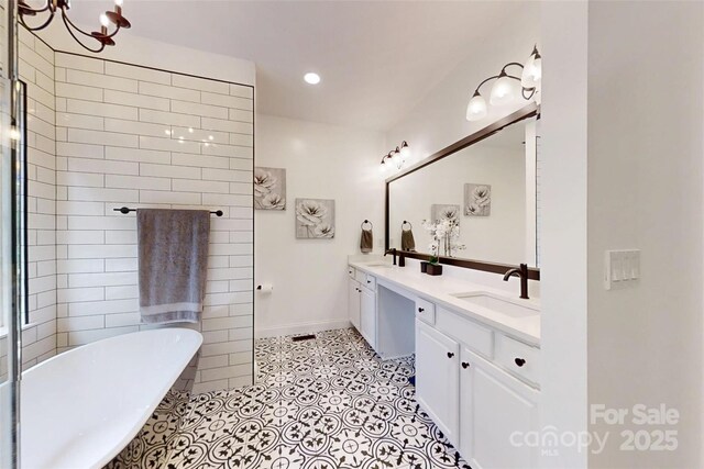 118 Tayport Dr, Troutman, NC 28166 - bathroom featuring a soaking tub, double vanity, a chandelier, baseboards, and recessed lighting