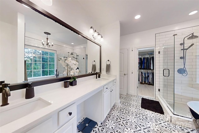 118 Tayport Dr, Troutman, NC 28166 - bathroom with a stall shower, double vanity, a spacious closet, recessed lighting, and a chandelier