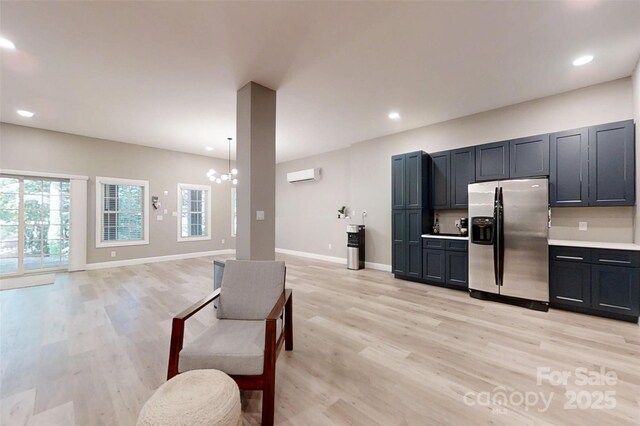 118 Tayport Dr, Troutman, NC 28166 - kitchen with stainless steel refrigerator with ice dispenser, light wood-style flooring, a chandelier, a wall unit AC, and open floor plan