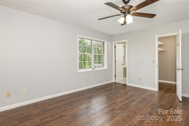 608 Surrey Glen Cir, Hendersonville, NC 28739 - unfurnished bedroom featuring a walk in closet, wood finished floors, baseboards, a closet, and a textured ceiling