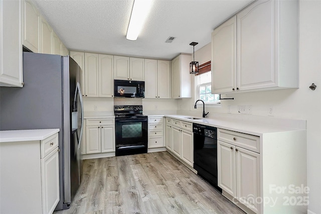 720 Reigate Rd, Charlotte, NC 28262 - kitchen with black appliances, light wood-style flooring, decorative light fixtures, light countertops, and a textured ceiling