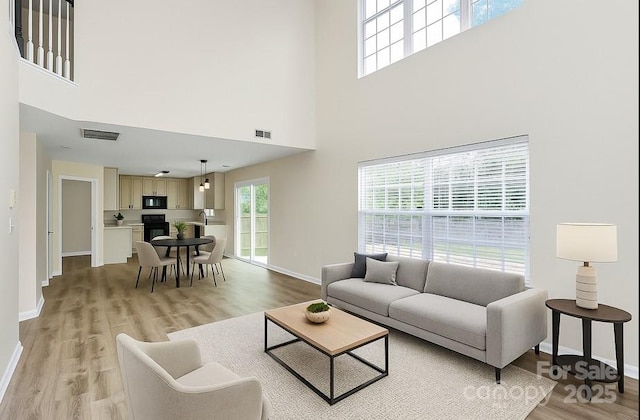 720 Reigate Rd, Charlotte, NC 28262 - living room featuring a towering ceiling and light wood-style floors