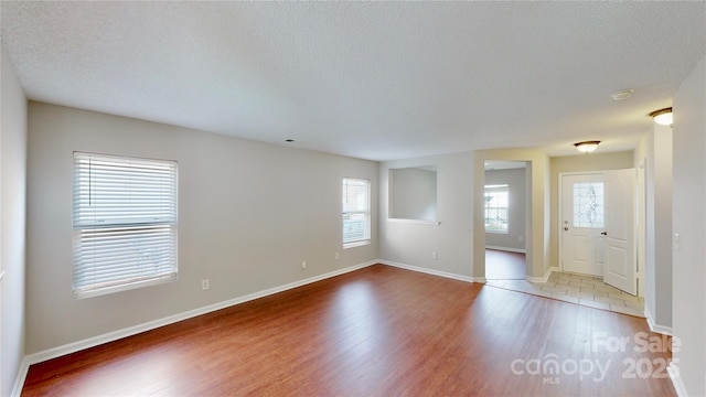 8139 Deodora Cedar Ln, Charlotte, NC 28215 - empty room with wood finished floors, a textured ceiling, and baseboards