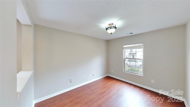 8139 Deodora Cedar Ln, Charlotte, NC 28215 - spare room with wood finished floors, baseboards, and a textured ceiling
