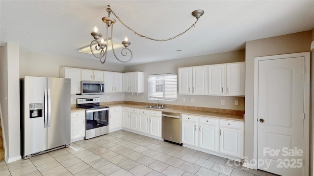 8139 Deodora Cedar Ln, Charlotte, NC 28215 - kitchen featuring appliances with stainless steel finishes, a sink, a chandelier, light countertops, and white cabinetry
