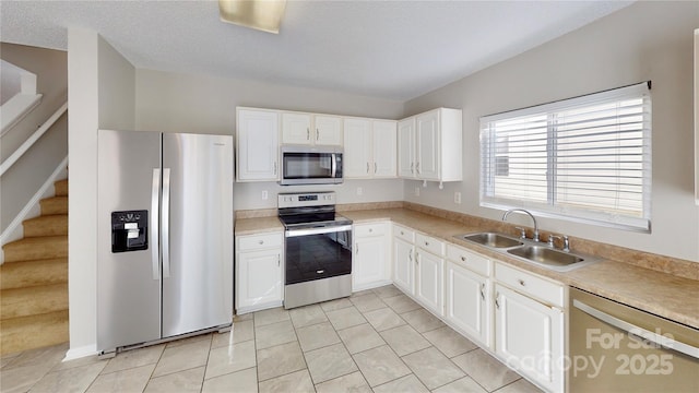 8139 Deodora Cedar Ln, Charlotte, NC 28215 - kitchen with appliances with stainless steel finishes, a sink, white cabinetry, light tile patterned floors, and light countertops