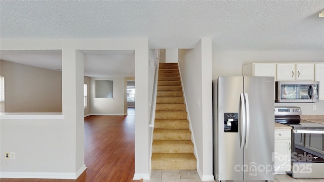 8139 Deodora Cedar Ln, Charlotte, NC 28215 - stairs featuring baseboards, wood finished floors, and a textured ceiling