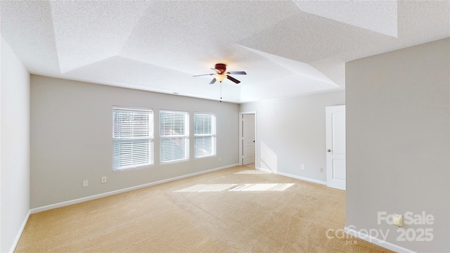 8139 Deodora Cedar Ln, Charlotte, NC 28215 - empty room featuring a tray ceiling, ceiling fan, light colored carpet, baseboards, and a textured ceiling