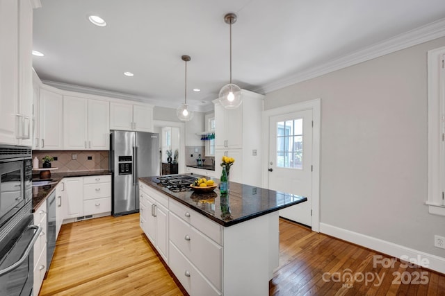 361 5th St NW, Hickory, NC 28601 - kitchen with stainless steel fridge, a kitchen island, gas stovetop, white cabinets, and light wood-type flooring