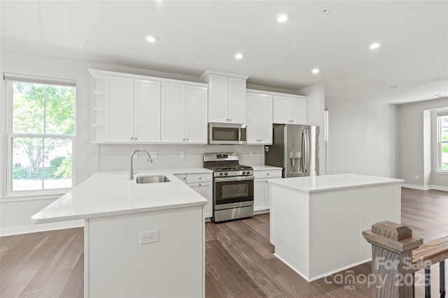 420 E 16th St, Charlotte, NC 28206 - kitchen with appliances with stainless steel finishes, a sink, a kitchen island, backsplash, and light countertops