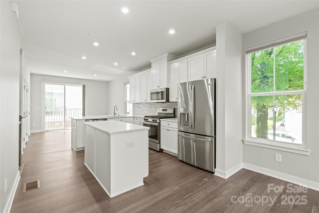 420 E 16th St, Charlotte, NC 28206 - kitchen featuring appliances with stainless steel finishes, a peninsula, dark wood-style floors, light countertops, and plenty of natural light