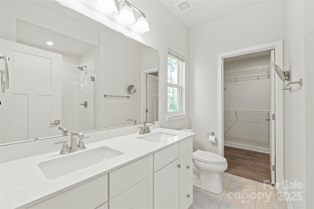 420 E 16th St, Charlotte, NC 28206 - bathroom featuring toilet, a tile shower, double vanity, a spacious closet, and tile patterned flooring