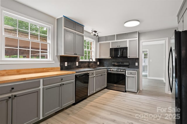 841 12th Ave NW, Hickory, NC 28601 - kitchen featuring black appliances, gray cabinetry, a sink, decorative backsplash, and light wood-style flooring