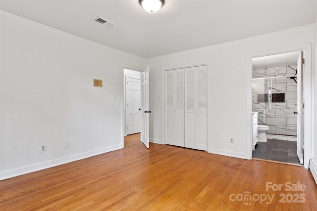 841 12th Ave NW, Hickory, NC 28601 - unfurnished bedroom with light wood finished floors, baseboards, and a closet