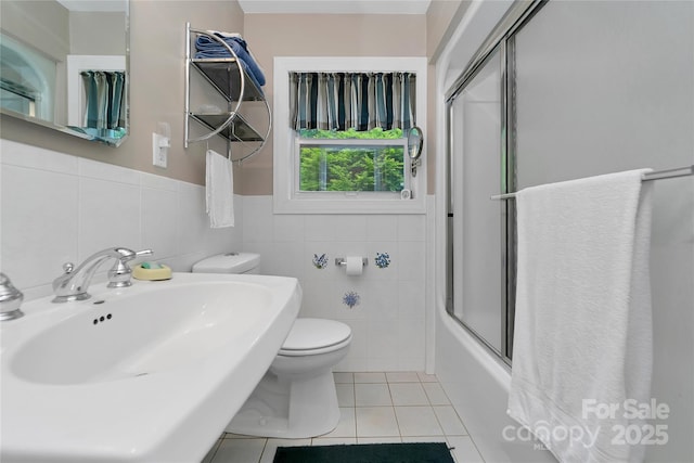 229 Hubbard Hollow Rd, Rosman, NC 28772 - full bath with tile patterned floors, tile walls, a wainscoted wall, and bath / shower combo with glass door