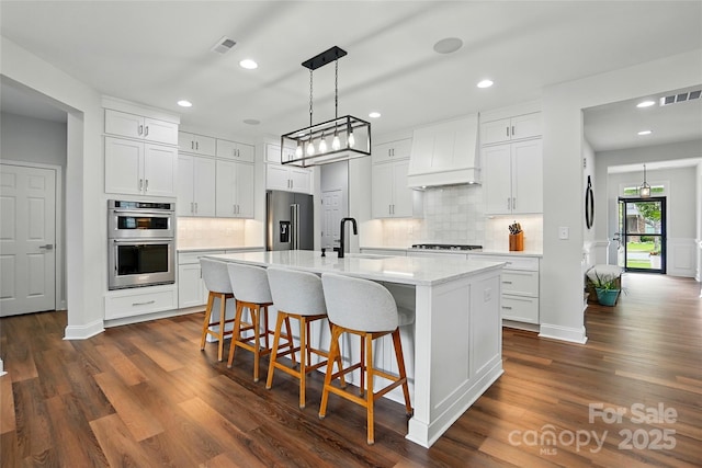 7322 Vesper Dr, Huntersville, NC 28078 - kitchen featuring stainless steel appliances, custom exhaust hood, backsplash, a kitchen bar, and recessed lighting