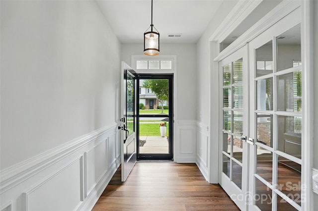 7322 Vesper Dr, Huntersville, NC 28078 - foyer entrance with french doors, a wainscoted wall, dark wood-style flooring, and a decorative wall