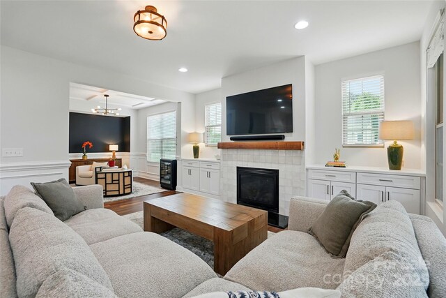 7322 Vesper Dr, Huntersville, NC 28078 - living area with wood finished floors, a tile fireplace, wainscoting, a chandelier, and recessed lighting