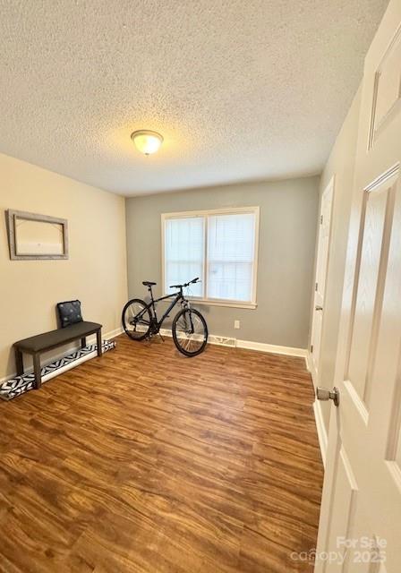 7133 Tall Tree Ln, Charlotte, NC 28214 - interior space featuring wood finished floors, a textured ceiling, and baseboards