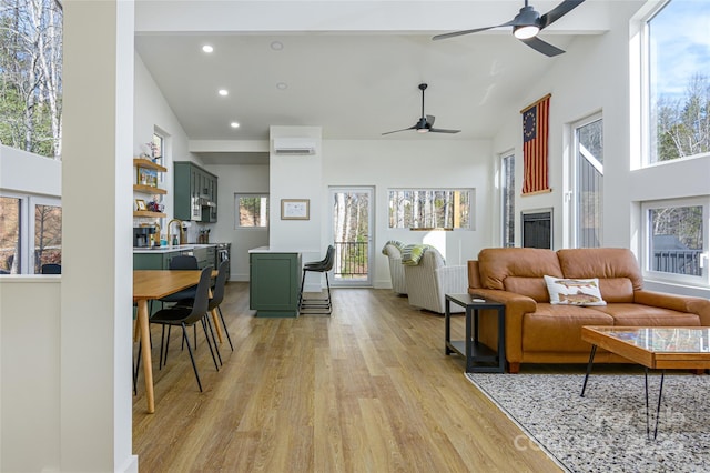 75 S Fork Trl, Lake Toxaway, NC 28747 - living room featuring a ceiling fan, light wood-type flooring, high vaulted ceiling, healthy amount of natural light, and an AC wall unit