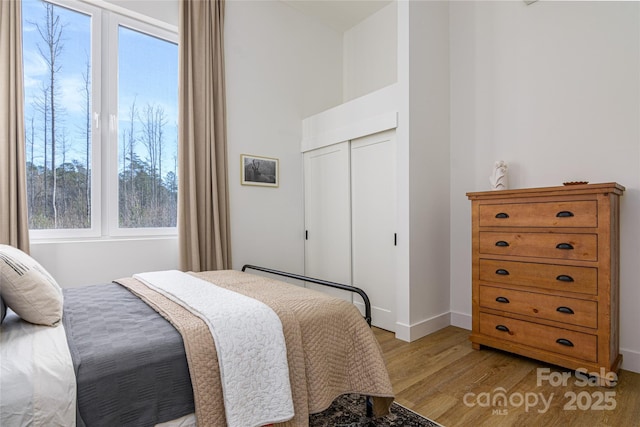 75 S Fork Trl, Lake Toxaway, NC 28747 - bedroom with light wood finished floors, a closet, and baseboards