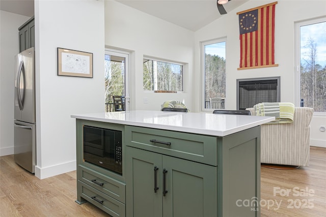 75 S Fork Trl, Lake Toxaway, NC 28747 - kitchen featuring green cabinets, freestanding refrigerator, black microwave, light wood-style flooring, and light countertops
