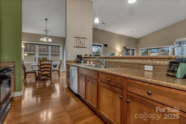 32 White Fox Dr, Fletcher, NC 28732 - kitchen featuring stainless steel dishwasher, a sink, brown cabinetry, dark wood-style floors, and a chandelier