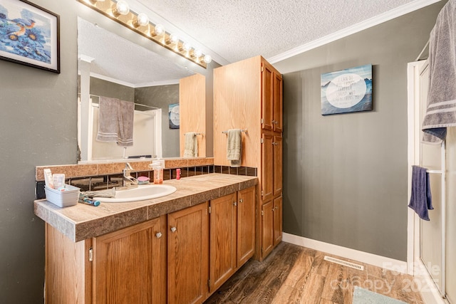 553 New Hope Rd, Rutherfordton, NC 28139 - bathroom featuring a textured ceiling, vanity, wood finished floors, crown molding, and a shower