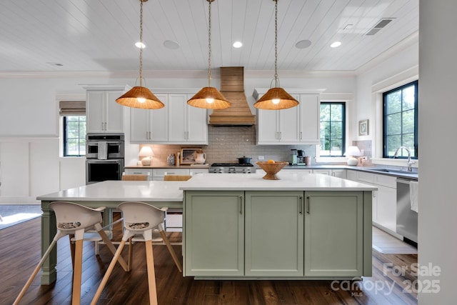 14105 Ryker Way, Davidson, NC 28036 - kitchen featuring appliances with stainless steel finishes, custom range hood, green cabinetry, a center island, and white cabinets