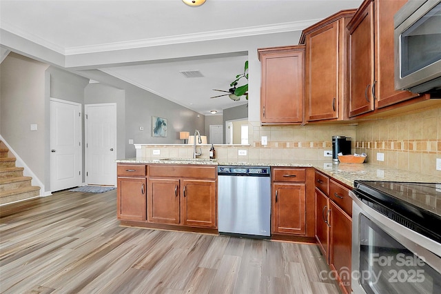 2840 Hopeton Ct, Monroe, NC 28110 - kitchen with stainless steel appliances, a sink, backsplash, light wood-style floors, and crown molding