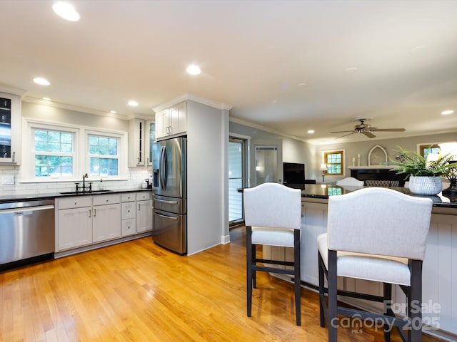 6941 Queensberry Dr, Charlotte, NC 28226 - kitchen with stainless steel appliances, a sink, dark countertops, backsplash, and crown molding