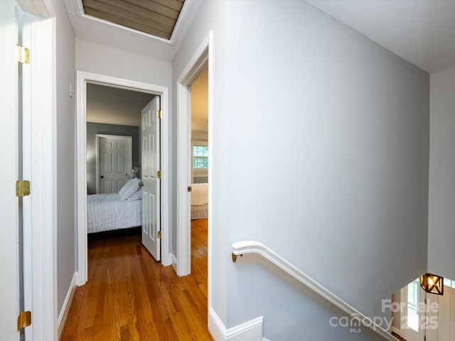 6941 Queensberry Dr, Charlotte, NC 28226 - hallway with an upstairs landing, wood finished floors, and baseboards